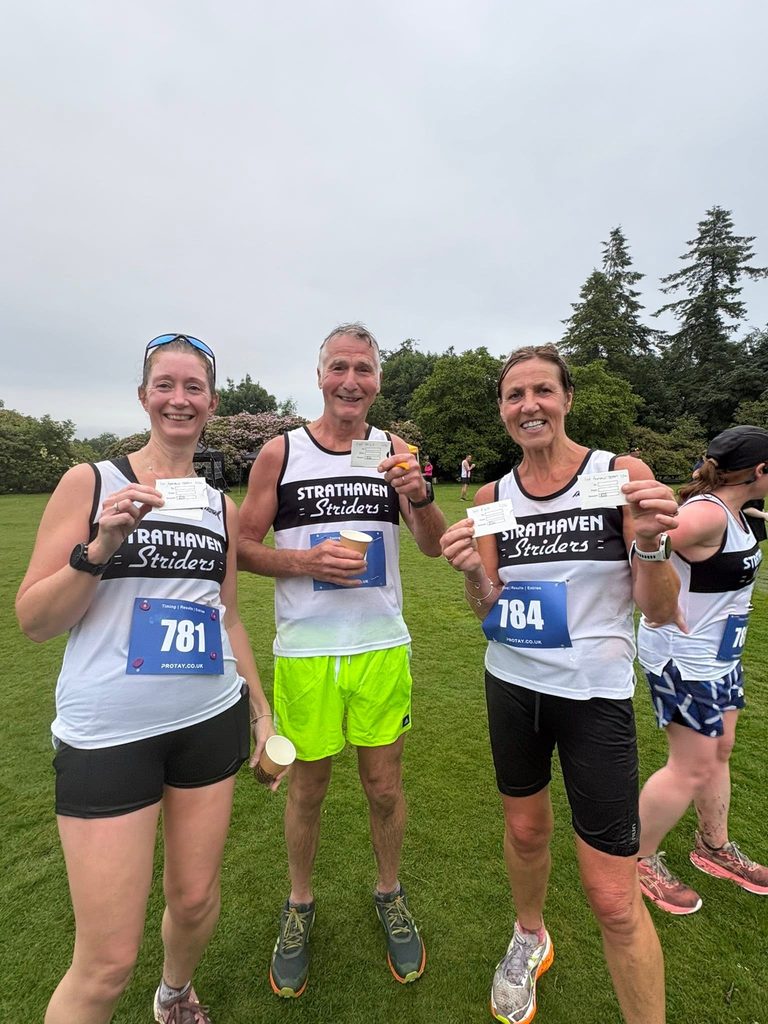 Male and two female runners wearing black and white Strathaven Striders running vests and holding white cards in their hands