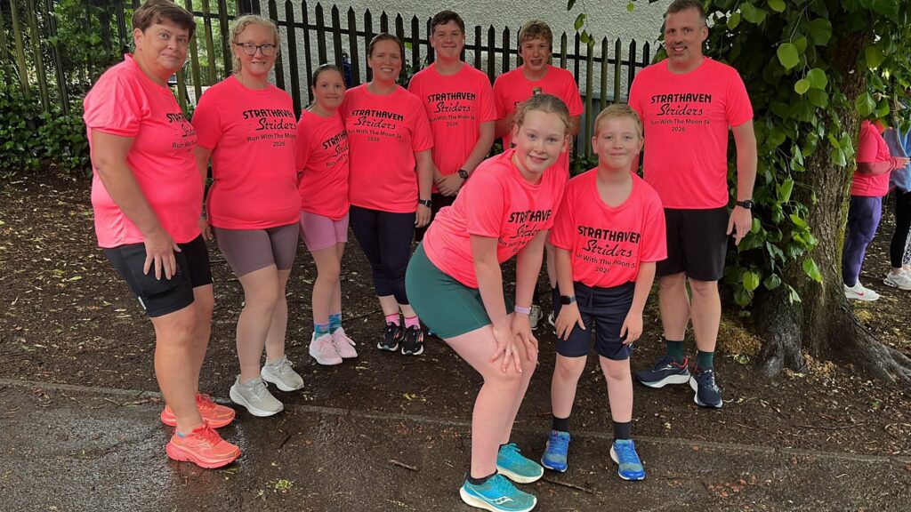 Group of junior and adult runners wearing bright pink running tshirts.