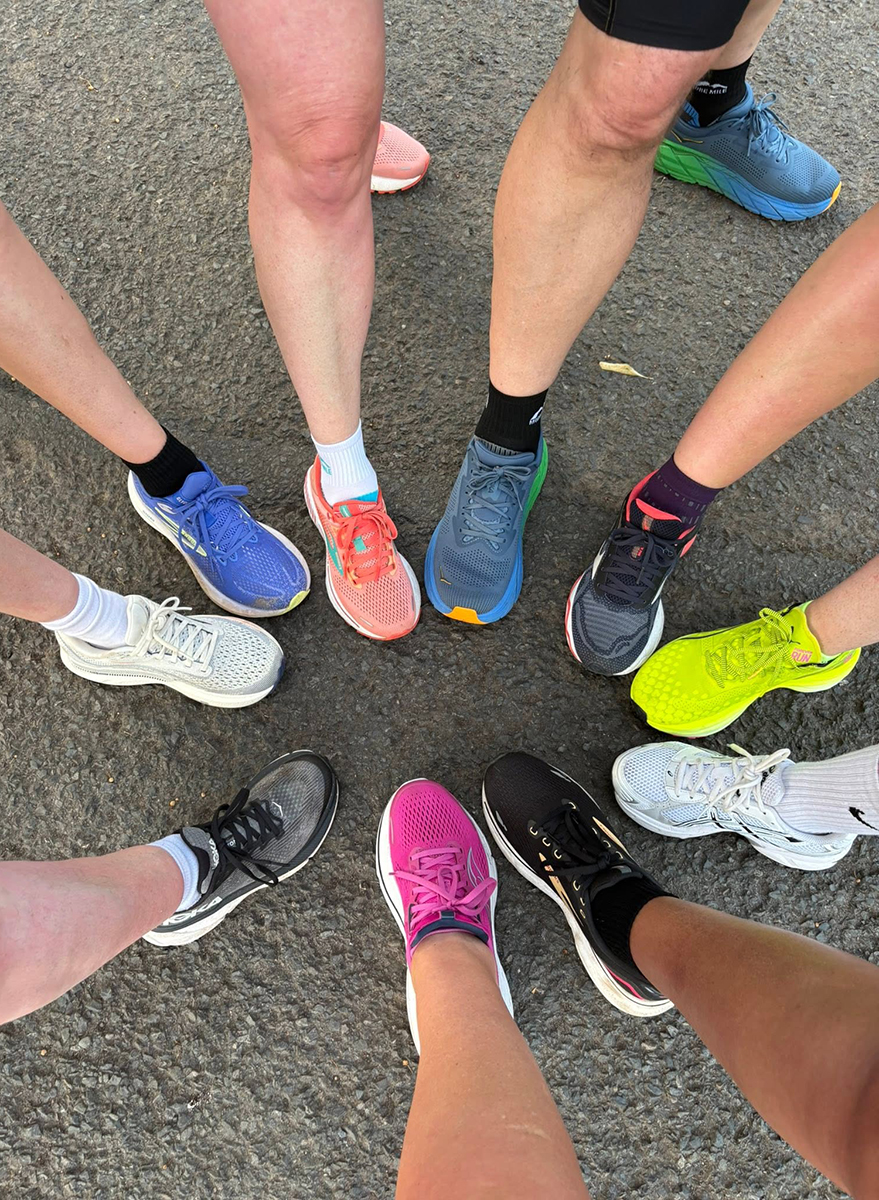 Group of runners standing with one foot forward in a circle, image shoes legs and feet with running shoes.
